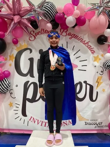 Gaby C., our Level 7 all-around champion, looking like a true superhero on the podium.