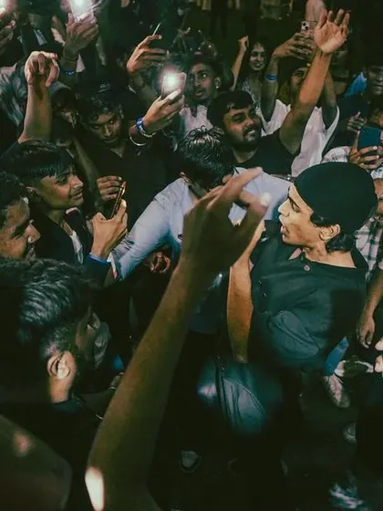 A photo capturing the raw energy of a mosh pit, with fans filming and fully immersed in the moment.