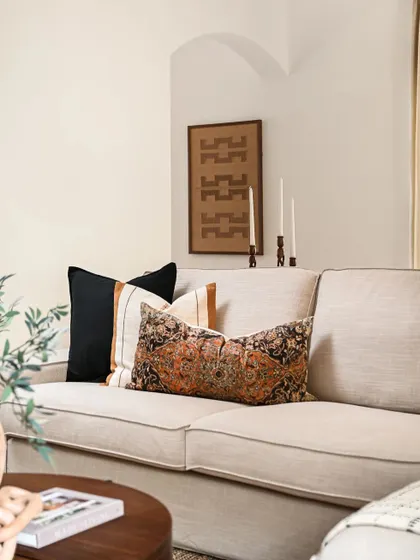 Details matter. I added this gentle archway between the foyer and living area to echo the Spanish architecture of the house. The framed rug on the wall adds texture, while the mix of patterns in the cushions creates a calm and collected feel.