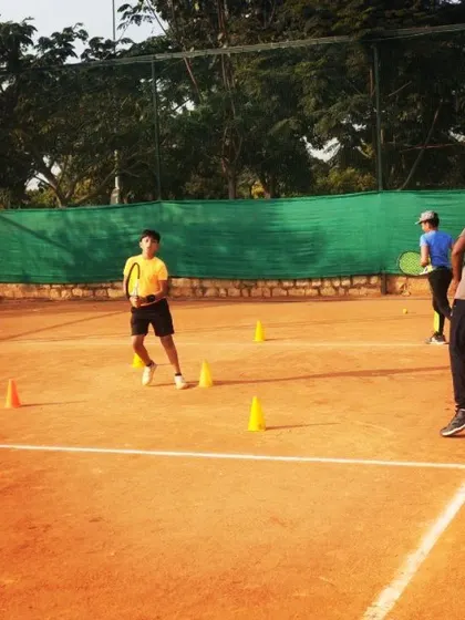 A young student navigates a cone drill, learning proper footwork and court positioning. These exercises are fundamental for developing movement skills.