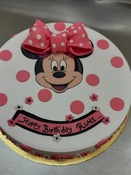 This Minnie Mouse cake uses a photo print of her face, surrounded by pink polka dots. It's a sweet and simple design that's perfect for a Minnie-themed birthday party.