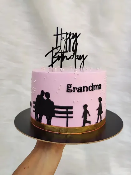 A thoughtful silhouette cake for a grandma's birthday, showing grandparents on a bench watching their grandchildren play.