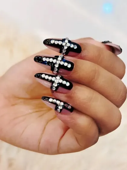 A side view of the dramatic rhinestone cross nail art.