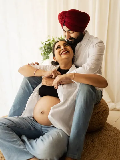 A tender and joyful moment from a lifestyle maternity shoot. The couple's laughter and loving embrace perfectly capture the excitement of this special time.