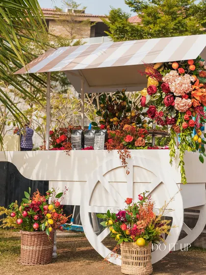 A charming bar cart, decorated with flowers and fruits, served as a hydration station. The striped canopy added a touch of whimsy to the setup.