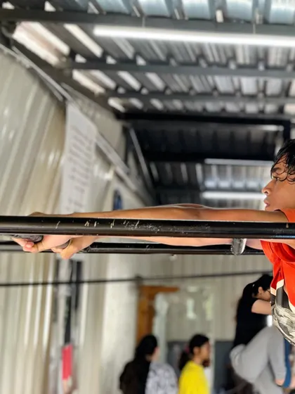 Mastering the art of movement, one routine at a time. This student holds a front lever prep on the bars, building the core strength needed for advanced calisthenics.