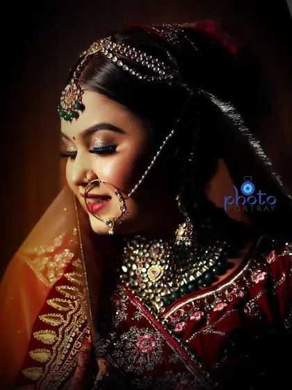 An elegant bridal portrait with warm, soft lighting, focusing on the bride's calm expression and the intricate details of her jewelry.