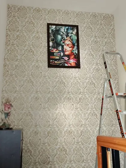 A damask wallpaper in a hallway, with a framed picture of Shiva and Parvati, creating a spiritual corner.