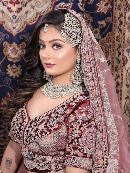 This bride's look is perfect for a reception or engagement. The makeup is glamorous with a defined eye, but the soft colors keep it looking modern and chic against her embroidered lehenga.