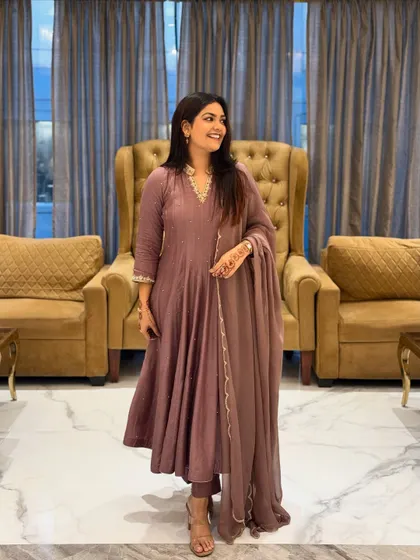 This mauve Anarkali suit set is a perfect example of understated elegance. The clean silhouette and delicate neckline embroidery make it ideal for a family dinner or a small festive gathering.