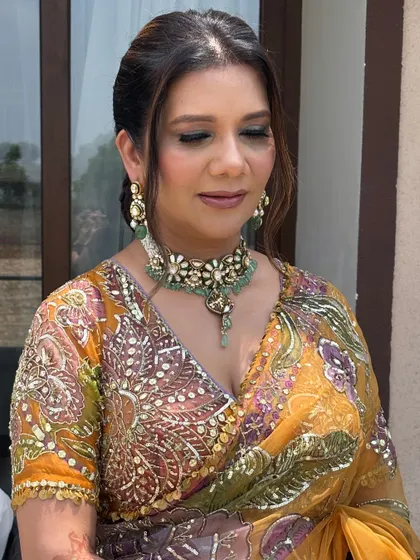 A close-up of the client's face, with the soft, braided front of her hairstyle visible.