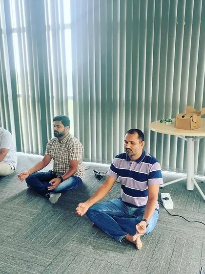A duplicate of the previous image, showing employees taking a moment to center themselves through guided meditation.