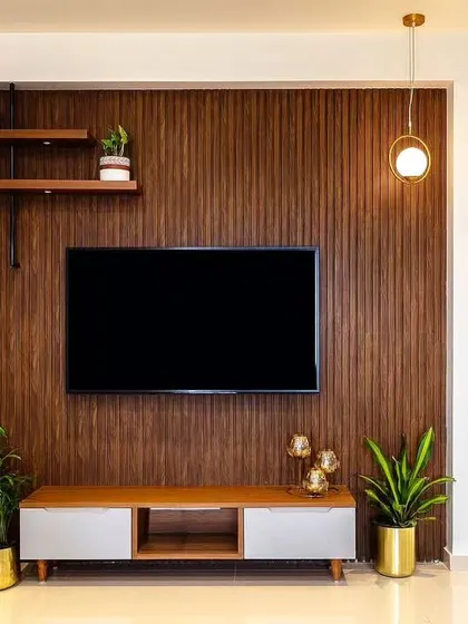 A clean and minimalist TV wall setup featuring vertical wood paneling. The simple floating console and open shelves provide just enough space for essentials, keeping the focus on the clean lines and natural texture.