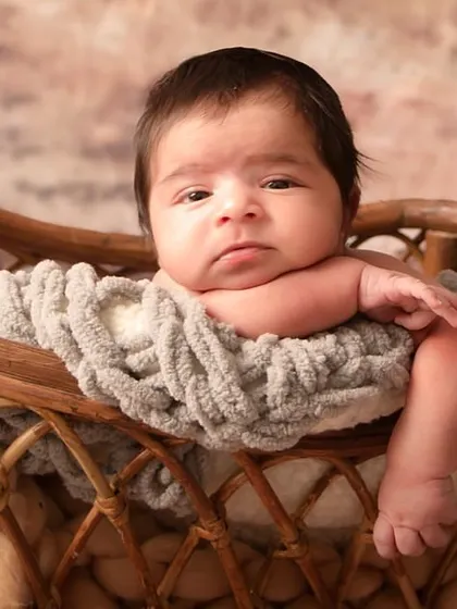 A close-up of this adorable newborn, capturing his thoughtful expression and tiny features. These are the details you will want to remember forever.