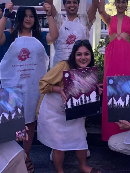 A group of friends proudly showing off their aurora paintings at a private party. The smiles on their faces say it all. What a fun way to celebrate together.