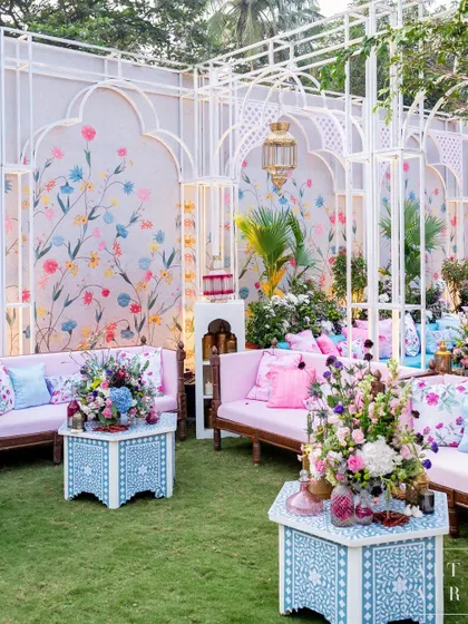 A seating area at 'Botanical Marrakesh', featuring hand-painted floral walls and intricate bone inlay tables. The design was a feast for the senses, transporting guests to an exotic world.
