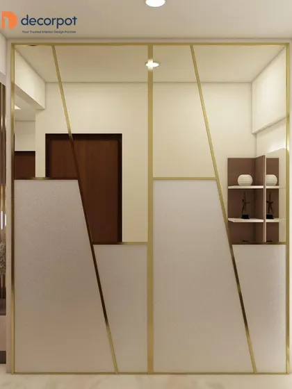 A minimalist sliding wardrobe design featuring an asymmetric pattern with gold-finish metal profiles. The combination of white and frosted panels creates a clean, architectural look.