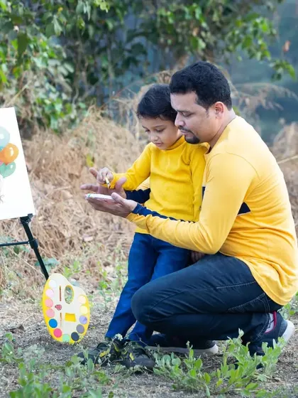A father helps his son with a painting during an outdoor creative session. I love capturing these moments of guidance and shared discovery.