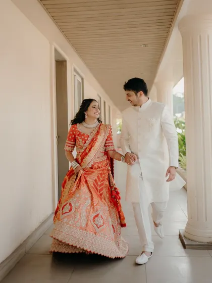 A classic walking shot of the engaged couple, hand in hand. Their coordinated outfits and happy smiles make for a perfect portrait.