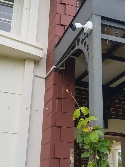 A wide shot showing the clean wiring and placement of a Hikvision camera on the exterior of a brick building.