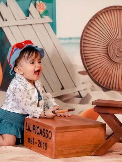 A happy baby enjoying the 'Lil Picasso' theme at the beach! We can combine themes for a truly unique photoshoot.