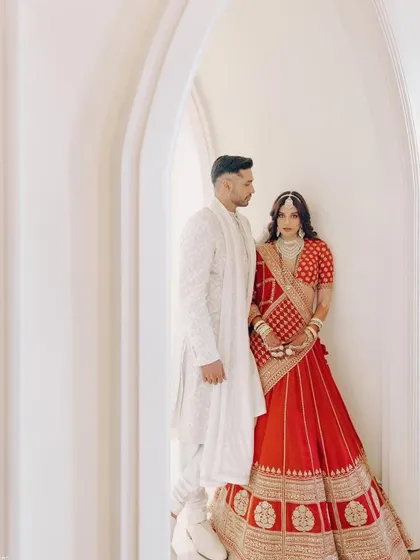 A full-length shot of the couple, Arjun Kanungo and Carla Dennis. I worked to ensure their outfits were perfectly coordinated, with Arjun in a classic white sherwani complementing Carla's red lehenga.