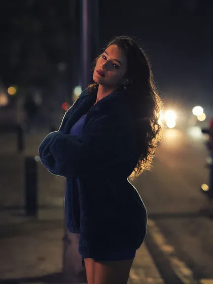 A confident night portrait of a woman on a city street, backlit by car headlights. The image has a strong, moody atmosphere that is characteristic of my urban cinematic photography.