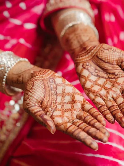 A close-up shot of the bride's intricate mehndi design. We focus on capturing the artistry and beauty of this important pre-wedding tradition.