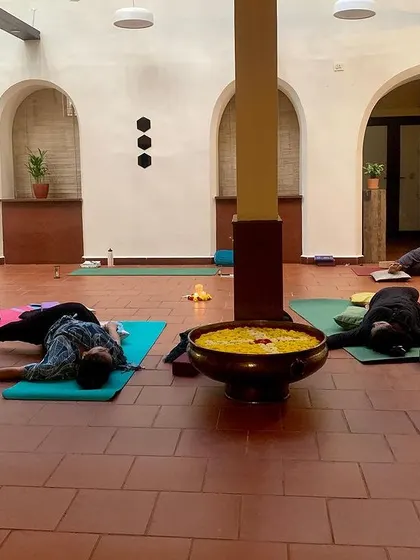 A group of participants resting deeply in Savasana. This moment of integration is one of the most important parts of our practice.
