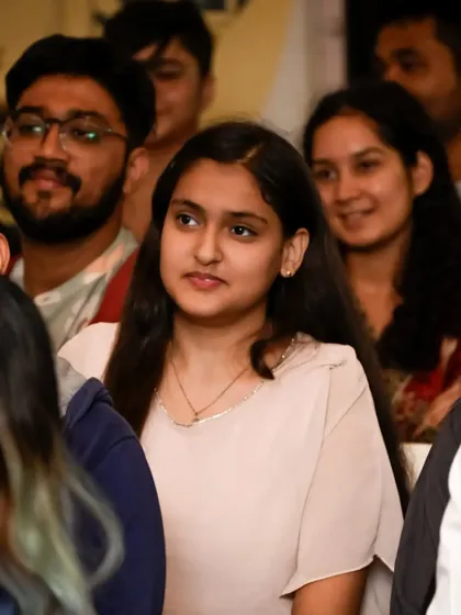 A portrait of an audience member, completely absorbed in the performance. The warm lighting and soft background help to isolate her and her focused expression.