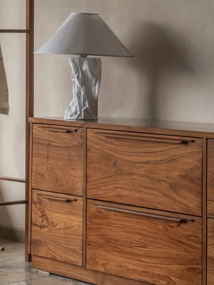 A close-up of the custom-built wooden console in the bedroom. The clean lines and beautiful grain of the teak wood showcase our focus on high-quality materials and bespoke furniture design.