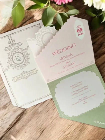 A pastel-themed wedding invitation in cream and sage green, featuring a modern die-cut pocket design and delicate gold foil accents.
