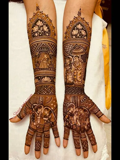 A beautiful and balanced design featuring the bride in a jharokha window, the couple under a ceremonial umbrella, and their portrait on the palms. The lotus motifs add a touch of purity and elegance.
