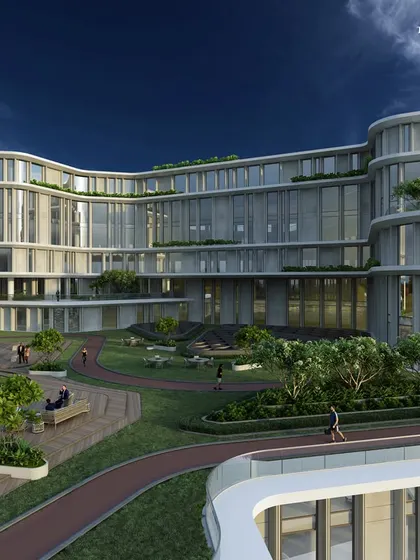 An eye-level view of the corporate headquarters, showing the integration of landscaped gardens and walking paths. This human-centric design provides employees with serene breakout zones, promoting well-being.
