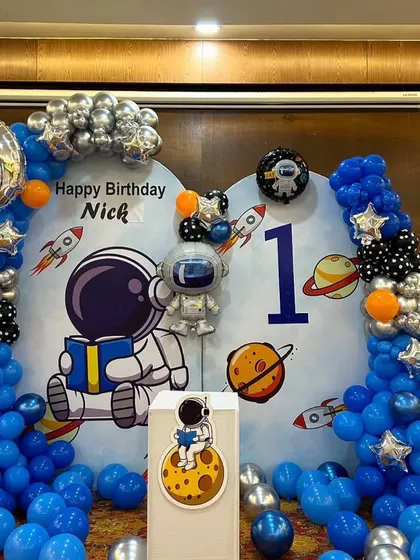 A detailed shot of the astronaut theme, highlighting the silver chrome and star-shaped foil balloons.