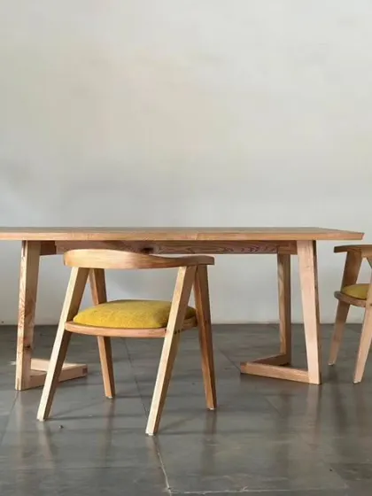 The Straight Edge Dining Table and accent chairs, a perfect blend of form and function. The design is minimalist yet warm, ideal for creating an inspired living space for dining and connection.