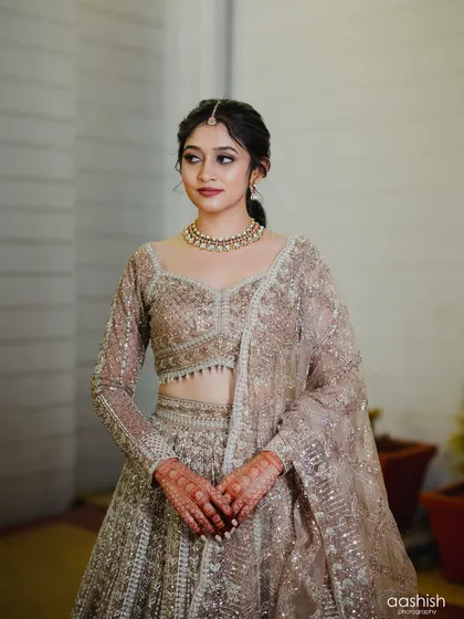 A solo portrait of the bride. Her makeup is modern and chic, and her hair is styled in a stylish ponytail.
