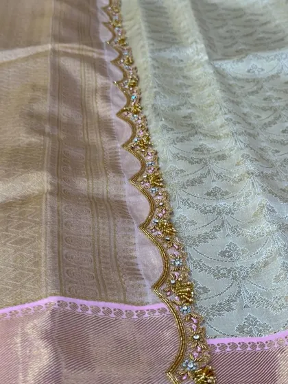A scalloped saree border with delicate floral embroidery.