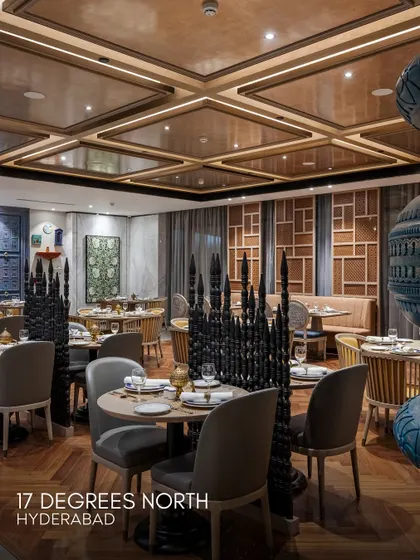 The dining room at 17 Degrees North, Hyderabad, where we blended traditional Hyderabadi aesthetics with contemporary design. The space features bespoke furniture, intricate screens, and a coffered ceiling, creating a luxurious and culturally rich atmosphere.