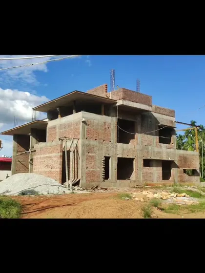 The raw brick and concrete structure of the farmhouse against the sky.