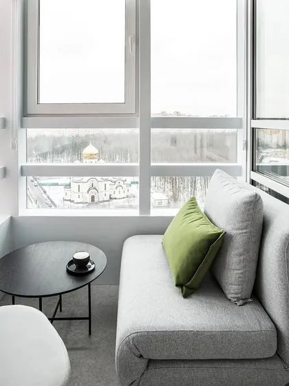 A cozy balcony seating area with a small sofa and coffee table, perfect for enjoying a cup of tea with a view. This shows our ability to design functional and beautiful small spaces.