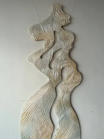 A different section of the "Whispering Waves" sculpture, showing the continuous, flowing lines that mimic water or wind.