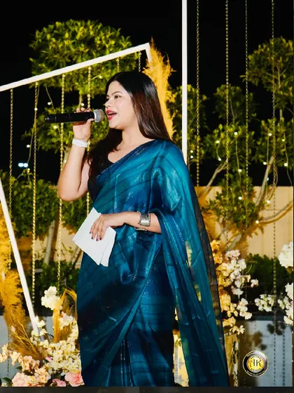 A solo shot from the same event, holding the mic and addressing the audience.