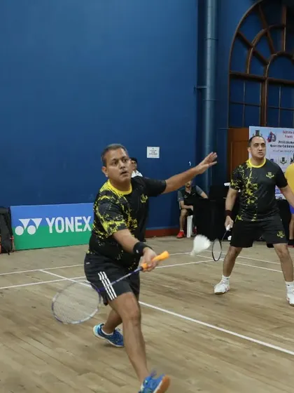 Two adult players engaged in a competitive doubles match during the GD Birla Memorial Masters Tournament.