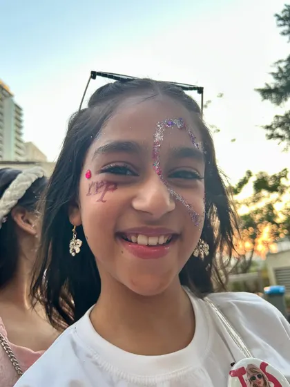Adding some glam and glitter for a Taylor Swift fan's 11th birthday. This young guest is rocking her sparkly face art.
