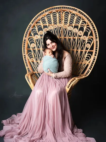 A queen on her throne. A new mother looking radiant in our client closet gown, holding her precious newborn.
