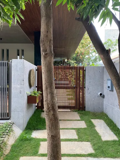 The stone pathway leading to the entrance, designed around an existing tree to create a natural and welcoming approach.