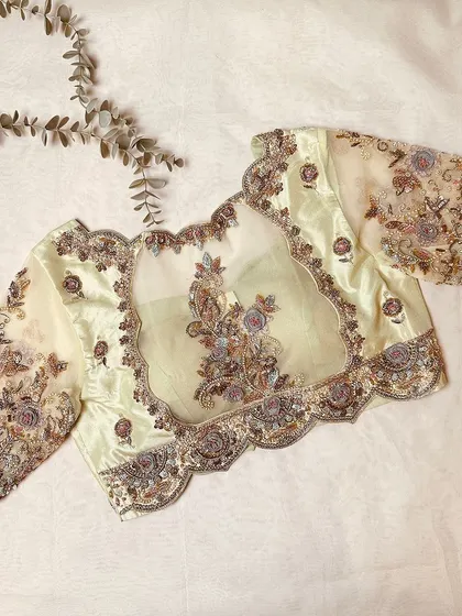 The back view of the pastel yellow blouse, showcasing the sheer panel and detailed cutwork.