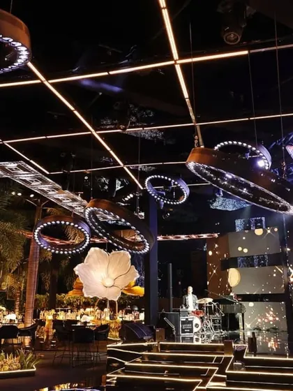 The ceiling design for this modern Sangeet featured circular LED lighting fixtures and a high-tech stage backdrop. This showcases my ability to integrate advanced lighting and AV for a concert-like experience.