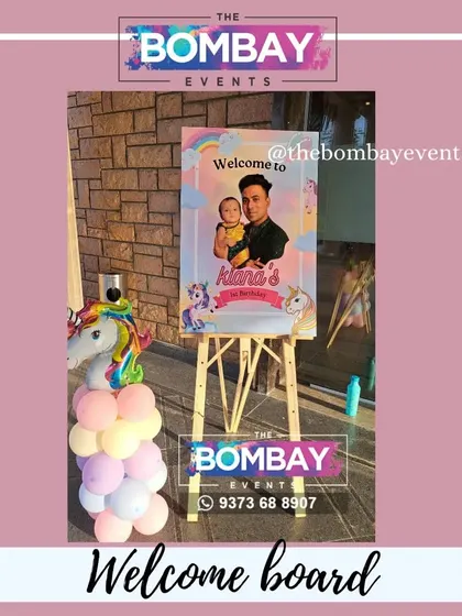 A personalized welcome board is a great way to greet guests. This one, designed for a unicorn-themed party, features a photo of the birthday girl and matches the party's decor.